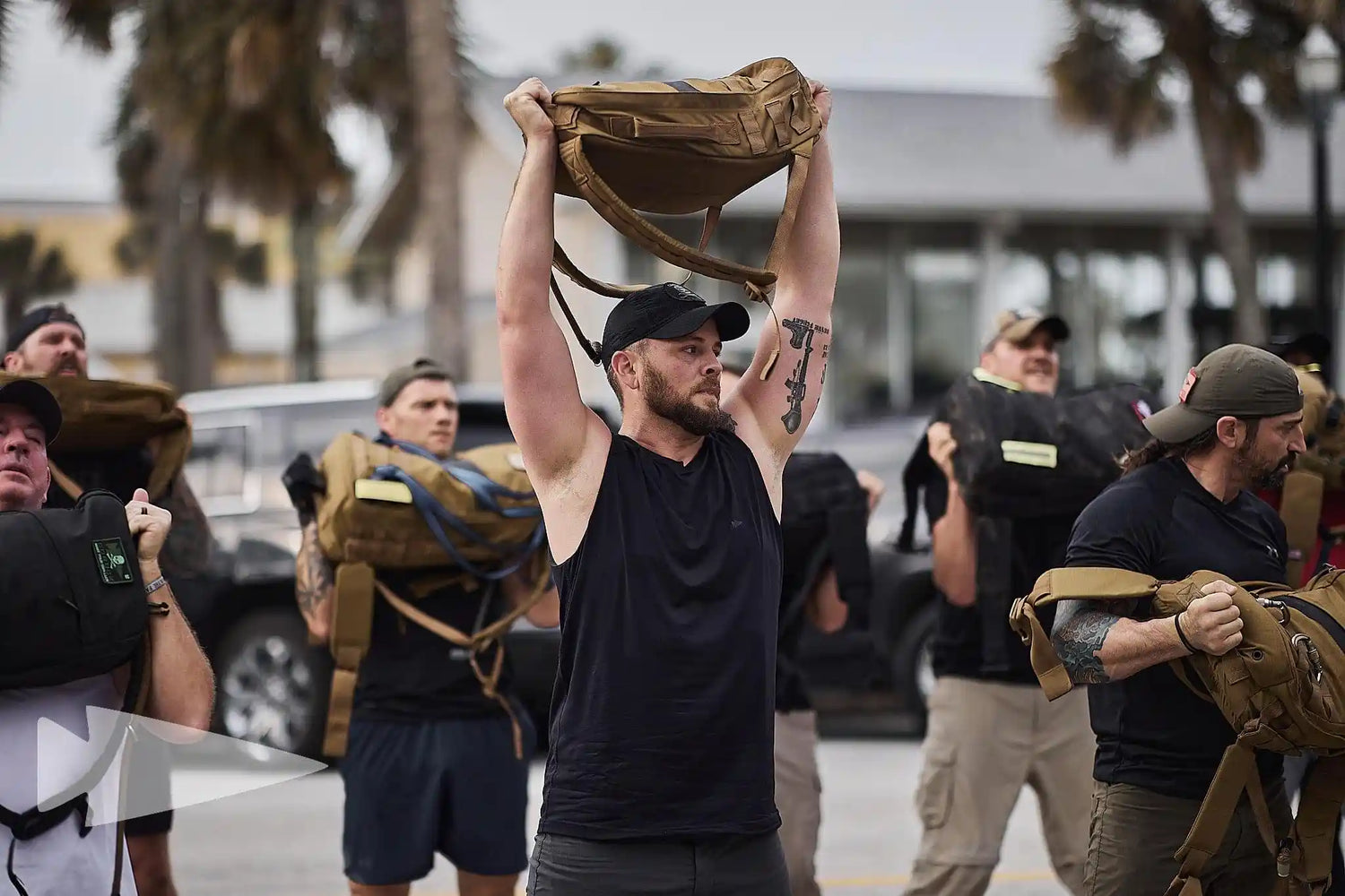 Group of people outdoors lifting GORUCK rucksacks during a rucking workout event