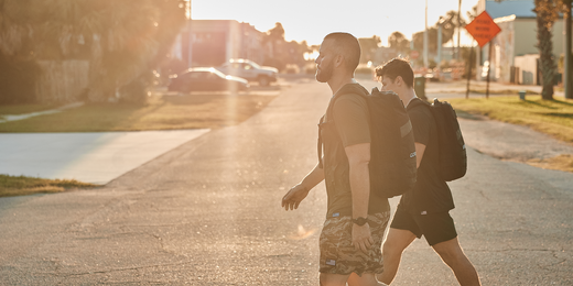 Two men rucking with GORUCK backpacks on a sunny street, fitness and outdoor training
