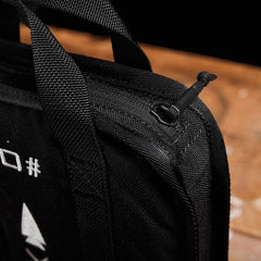 Close-up of GORUCK black ruck plate carrier handle and zipper on a wooden surface
