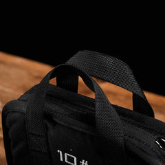 GORUCK 10lb black ruck weight with sturdy nylon handles on wooden surface