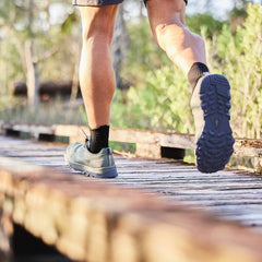 Man rucking in GORUCK shoes on a wooden trail bridge outdoors