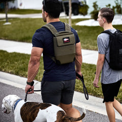 Man wearing GORUCK rucksack walking dog with teenager outdoors, showcasing rucking gear