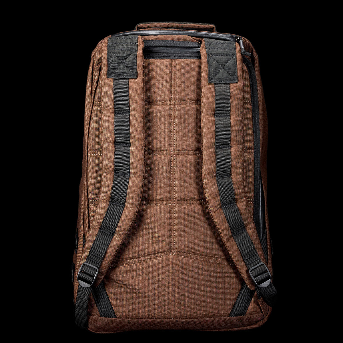 The GR1 rucksack in brown features black padded shoulder straps and a top handle, displayed against a black background.