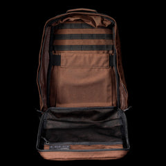 The GR1 rucksack, in open brown, showcases multiple interior compartments and mesh pockets against a black background.