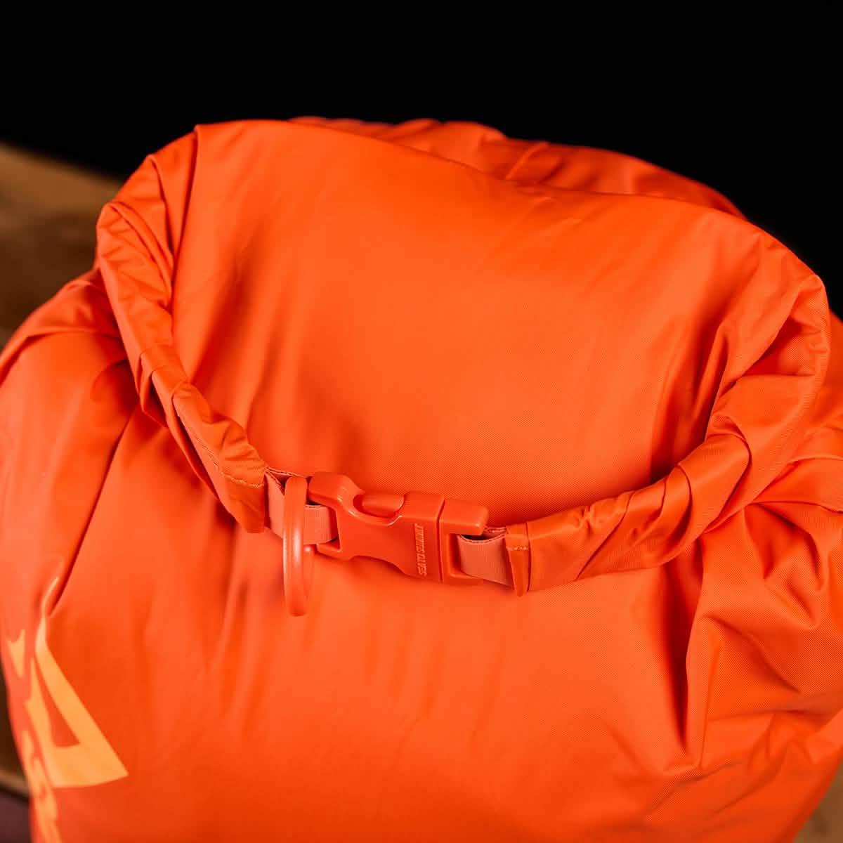 Bright orange GORUCK dry bag with roll-top closure and secure buckle for outdoor rucking gear
