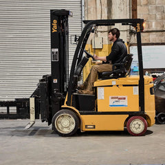 Man operating yellow Yale forklift in industrial warehouse, GORUCK workplace scene