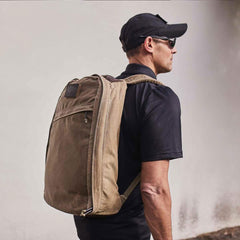Man wearing GORUCK tan rucksack outdoors, showcasing durable rucking backpack gear.