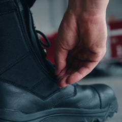Close-up of hand adjusting black GORUCK rucking boot with side zipper for rugged outdoor use