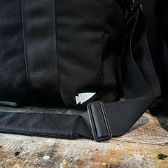GORUCK black rucking bag shoulder strap detail on rustic wooden surface