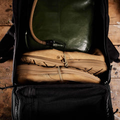 GORUCK rucksack open showing tan boots and green hydration bladder packed for rucking