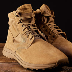 GORUCK tan rucking boots with suede and mesh, rugged sole, on wooden surface