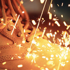 GORUCK tan rucking boot with sparks flying, showcasing tough, durable footwear.