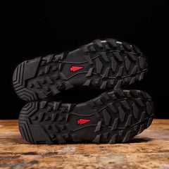GORUCK rucking boots with rugged soles and red arrowhead logo on wooden surface