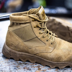 GORUCK tan rucking boot with rugged sole on a textured surface, close-up view
