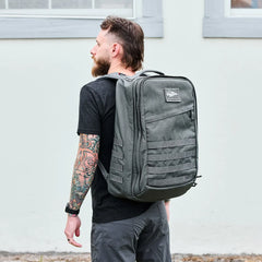 Man wearing a large grey GORUCK rucksack outdoors, showcasing durable rucking gear