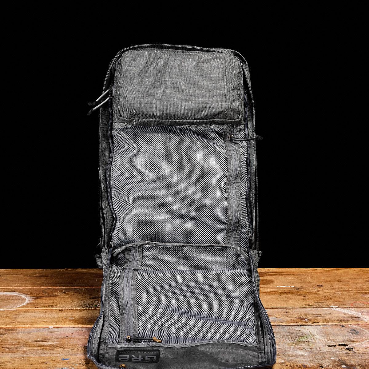 GORUCK Armor Grey rucksack open on wood table, showing mesh compartments and rugged design