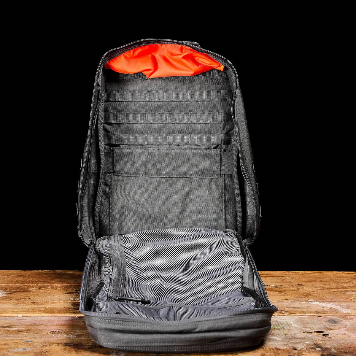 GORUCK open rucksack with orange lining and mesh pocket on wooden table