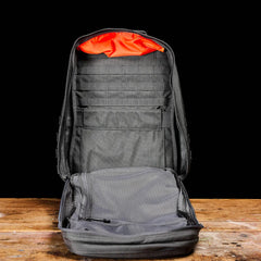 GORUCK open rucksack with orange lining and mesh pocket on wooden table