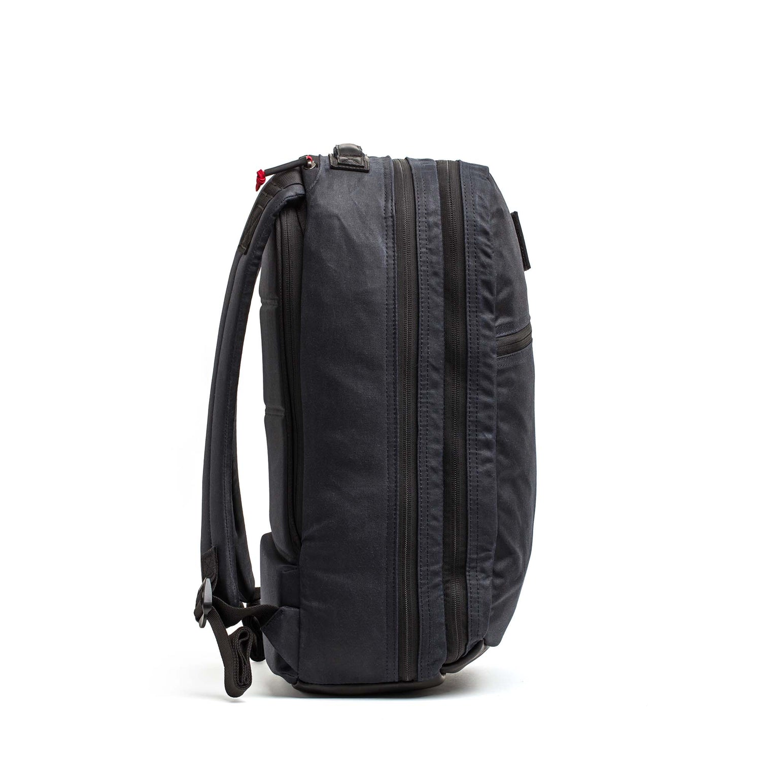 The Double Compartment Bullet Ruck - Heritage Waxed Canvas - 18L stands upright, displayed from the side against a plain white background.