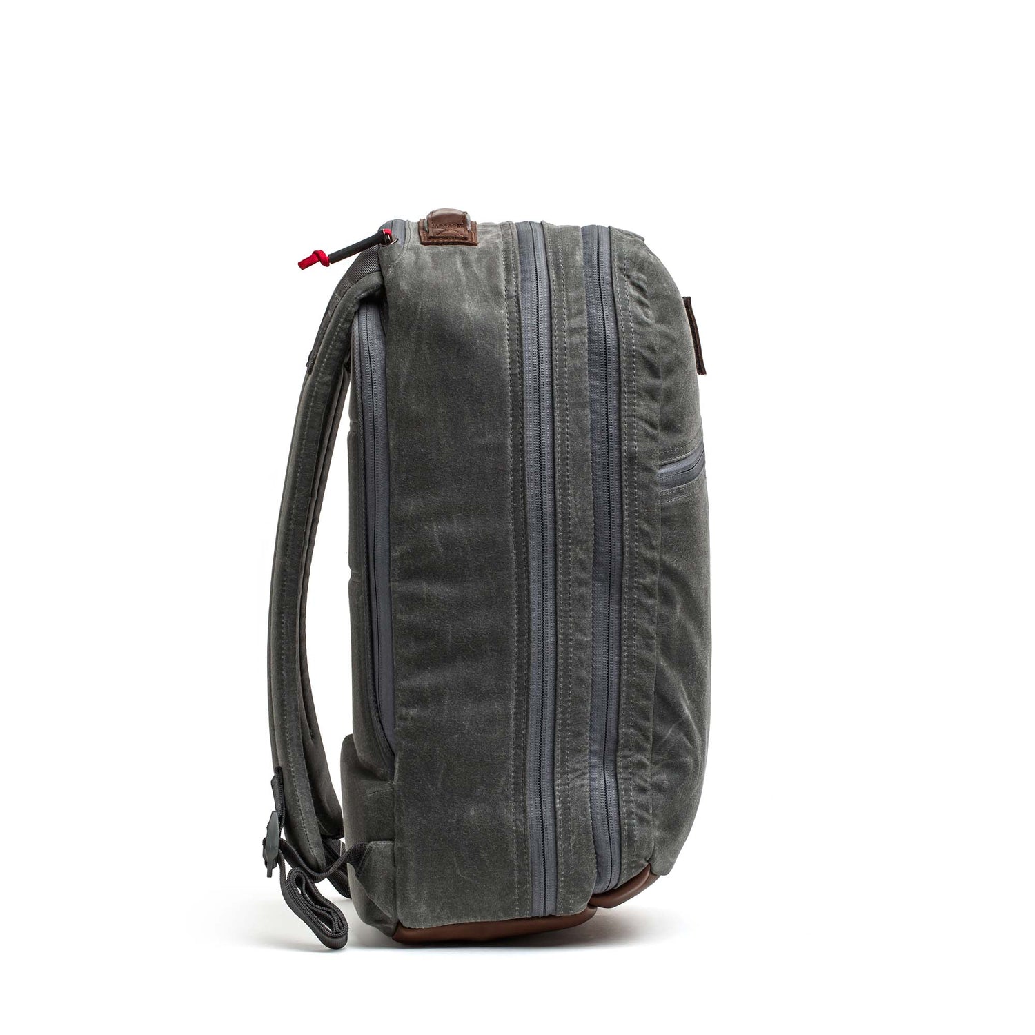 Side view of the Double Compartment Bullet Ruck - Heritage Waxed Canvas - 18L in gray, featuring two main zippered compartments and padded shoulder straps—perfect for use as a travel daypack.