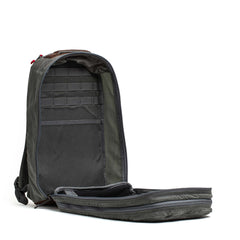 The Double Compartment Bullet Ruck - Heritage Waxed Canvas - 18L, shown fully unzipped, displays its roomy interior and convenient inner pockets—ideal as a rugged travel daypack.