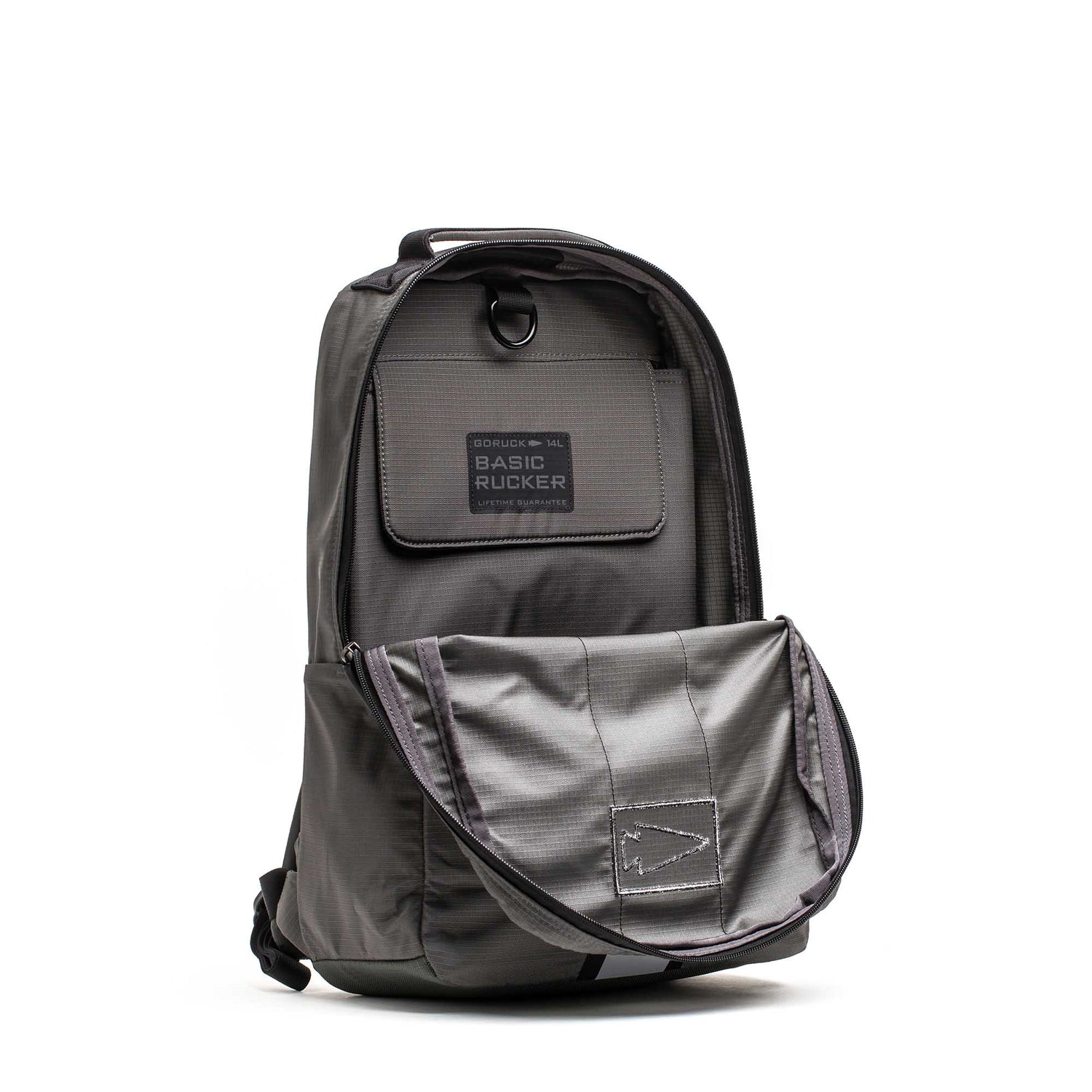 Basic Rucker in gray shown with its front flap pocket open, revealing a spacious interior compartment designed to fit a ruck plate, and featuring a sturdy top handle—ideal for all your rucking adventures.