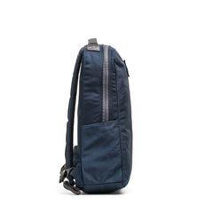 Side view of the Basic Rucker in navy blue, featuring a front zipper pocket and adjustable shoulder straps, designed for rucking and compatible with a standard ruck plate, shown on a white background.