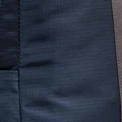 Close-up of dark blue fabric with a vertical seam and visible stitching details, similar to the rugged materials used in the Basic Rucker.
