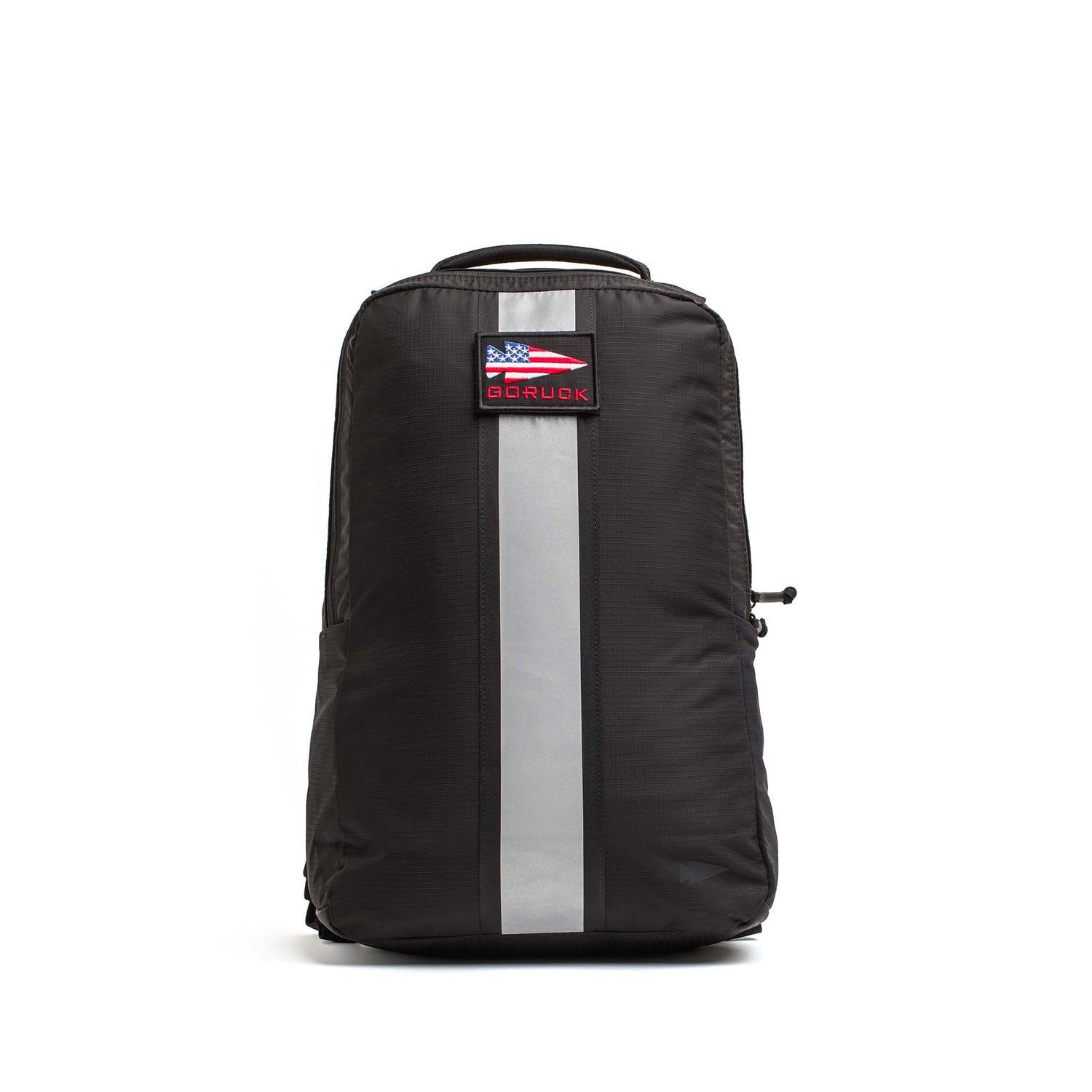 The Basic Rucker, shown in black with a reflective vertical stripe and an American flag patch on the front. Photographed on a white background, it’s designed for rucking and is compatible with a ruck plate.
