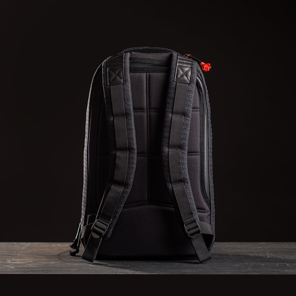 Limited-edition Bullet Ruck x Carryology - GRXC2 Samurai 2.0: Black backpack with padded shoulder straps, inspired by the Samurai Bullet Ruck, shown standing upright against a dark background.