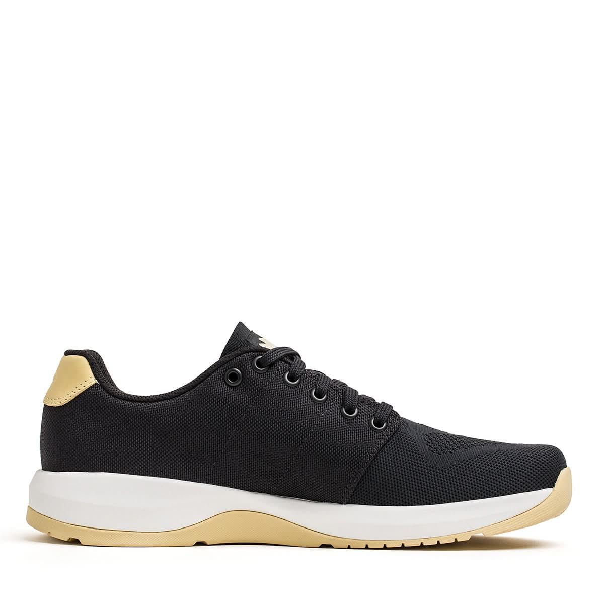GORUCK Ballistic Trainer black sneaker with gold heel and white sole on white background