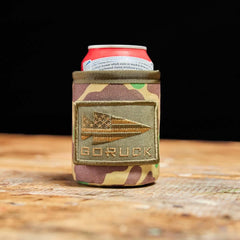 GORUCK camouflage can koozie with logo patch on wooden surface