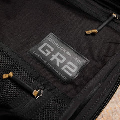 Close-up of GORUCK GR2 40L black rucksack with lifetime guarantee label and zippers