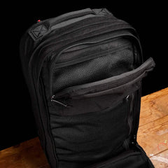 GORUCK Black 40L rucksack open, showing mesh interior pockets on wooden surface