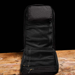 GORUCK black rucksack open flat on rustic wood table, showing mesh interior compartments
