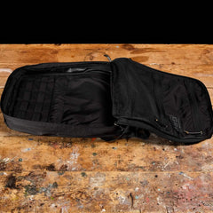 The GR0 - Ripstop ROBIC® rucksack with mesh pockets rests on a worn wooden surface, ideal for minimalist everyday carry.