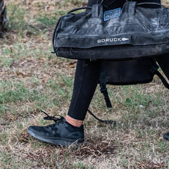 GORUCK sandbag and black rucking shoes on grass, outdoor fitness training gear