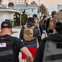 Group of people rucking outdoors wearing GORUCK tactical backpacks and Boonie hat