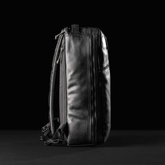GORUCK Bullet 15L black leather backpack upright on black background, highlighting rugged design