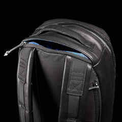 Close-up of GORUCK black rucksack shoulder straps and zippered compartment on black background