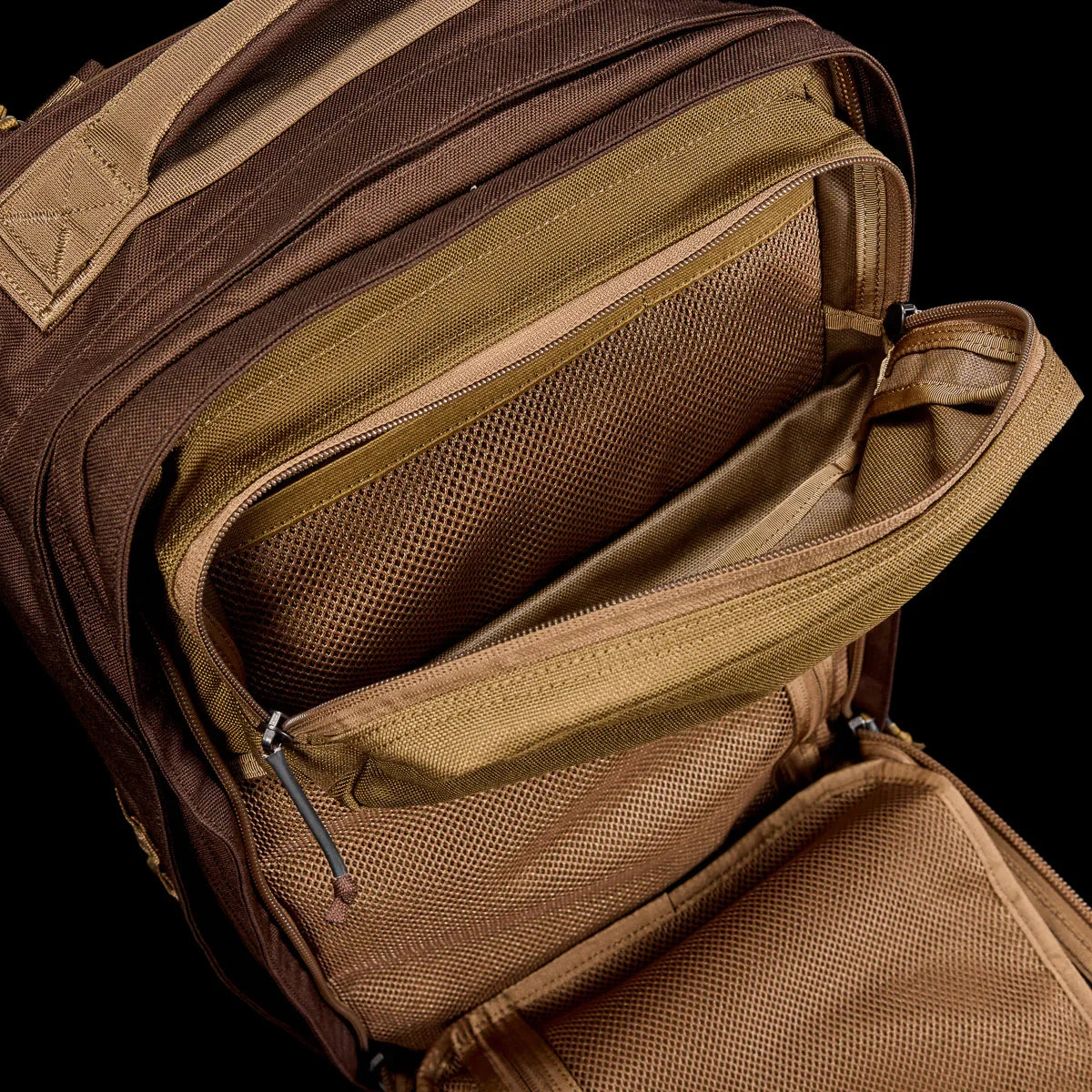 GORUCK brown tactical backpack showing open organized mesh pockets and rugged zippers