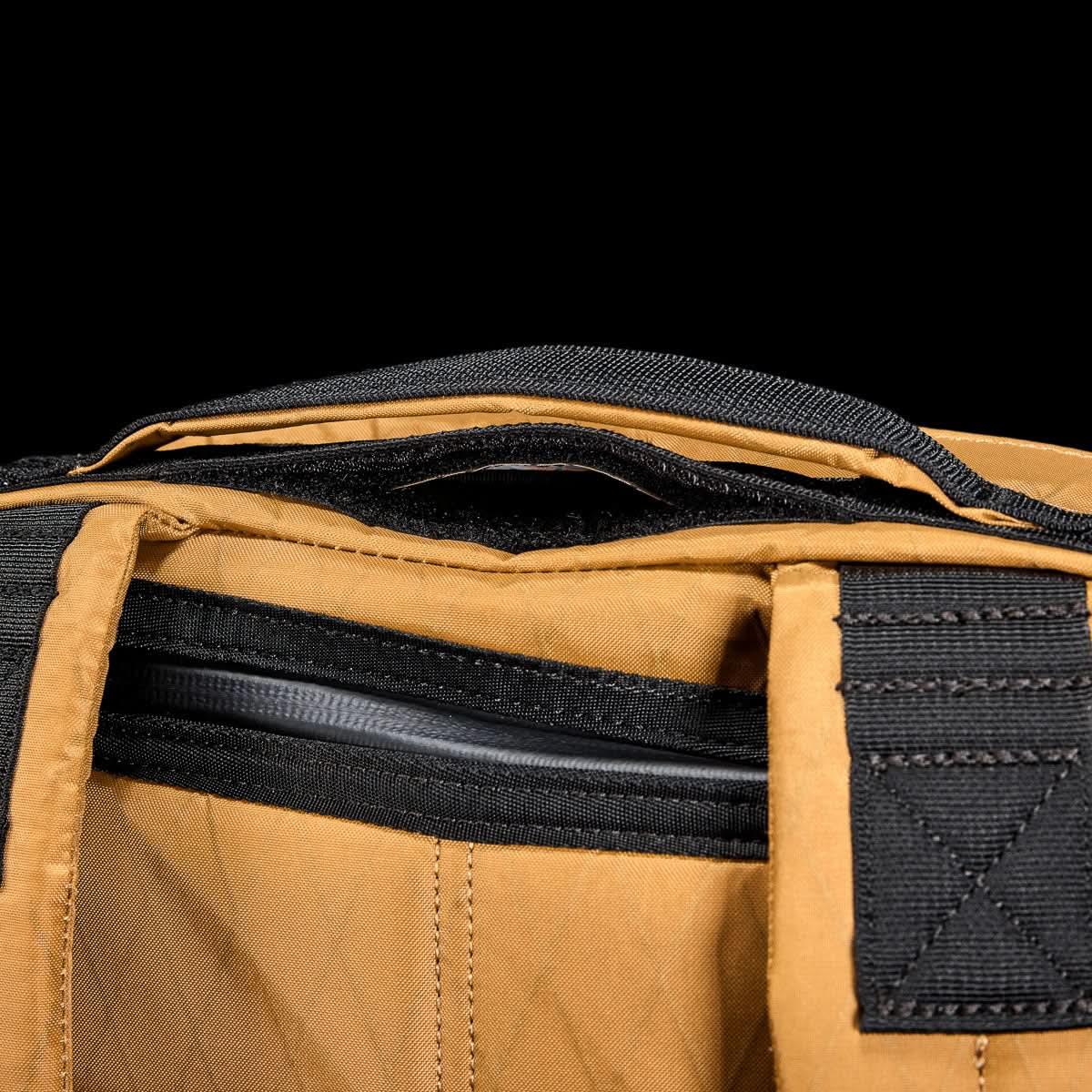 Close-up of GORUCK coyote brown rucksack with black stitching and zipper detail