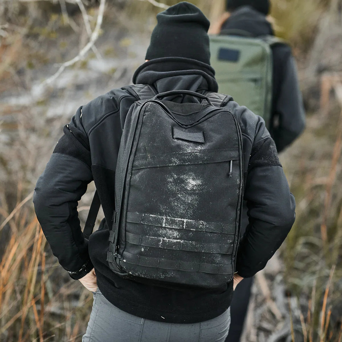 Person rucking outdoors with rugged GORUCK black backpack and outdoor gear