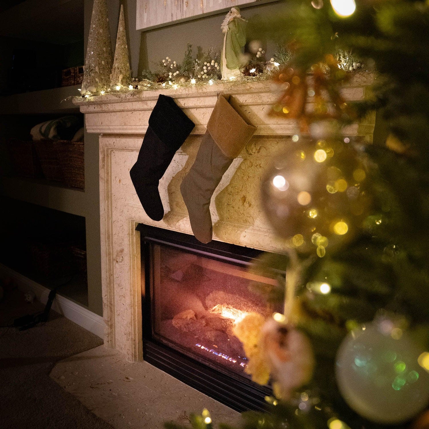 GORUCK Christmas stockings hanging on a decorated fireplace with holiday lights and tree