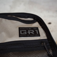 Close-up of the GR1 label reading "Built in the USA" beside a mesh pocket, showcasing this everyday carry backpack inspired by Special Forces design.