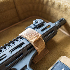 A close-up of a rifle secured with the Retention Package inside a padded, brown case.