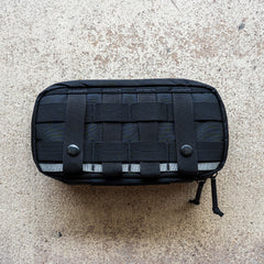 IFAK (Black + Red Thread + Grey Interior + Red Patch) ROBIC w/ Aquaguard, featuring webbing and snap buttons, displayed on a textured beige surface.