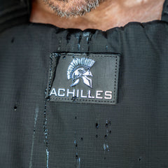 Close-up of the Achilles | Men's Weighted Vest featuring a Spartan helmet logo and water droplets on its premium exterior.