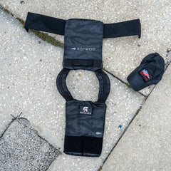 The Achilles | Men's Weighted Vest, shown with a matching cap and patches on a concrete sidewalk, combines style and functionality to enhance your workouts.