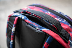 Close-up of the Bullet Ruck Classic - Ballistic Nylon Cordura’s streamlined handle with red, blue, and white patterned fabric—ideal for your 15L daypack or rucking backpack needs.